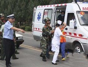 医务人员将受伤群众扶上救护车